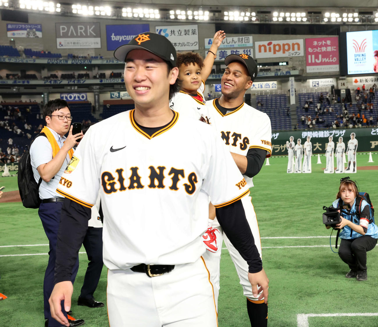 巨人対DeNA 30試合連続無失点の巨人マルティネス（右奥）は場内1周後、笑顔で愛息ルーカス君を抱っこする。手前は山崎（撮影・浅見桂子）