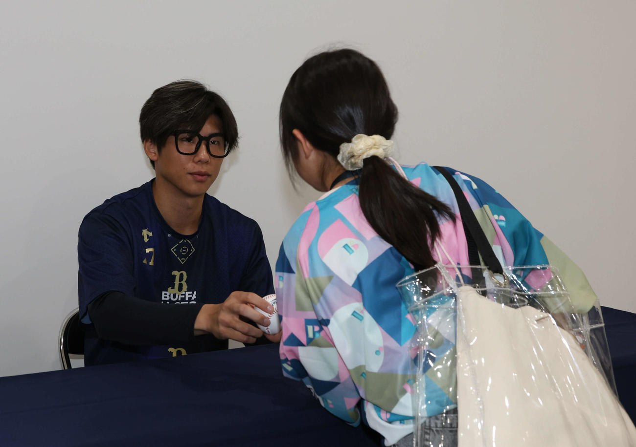 オリックス恒例の「オリ姫デー」初日、メガネ姿でファンにサインする曽谷（撮影・西尾就之）