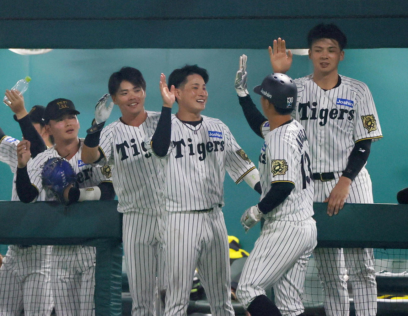 ウエスタン・リーグ阪神対中日　8回裏阪神1死三塁、藤田の左前適時打で生還した三塁代走川崎（手前）を出迎える阪神の選手ら（撮影・上山淳一）