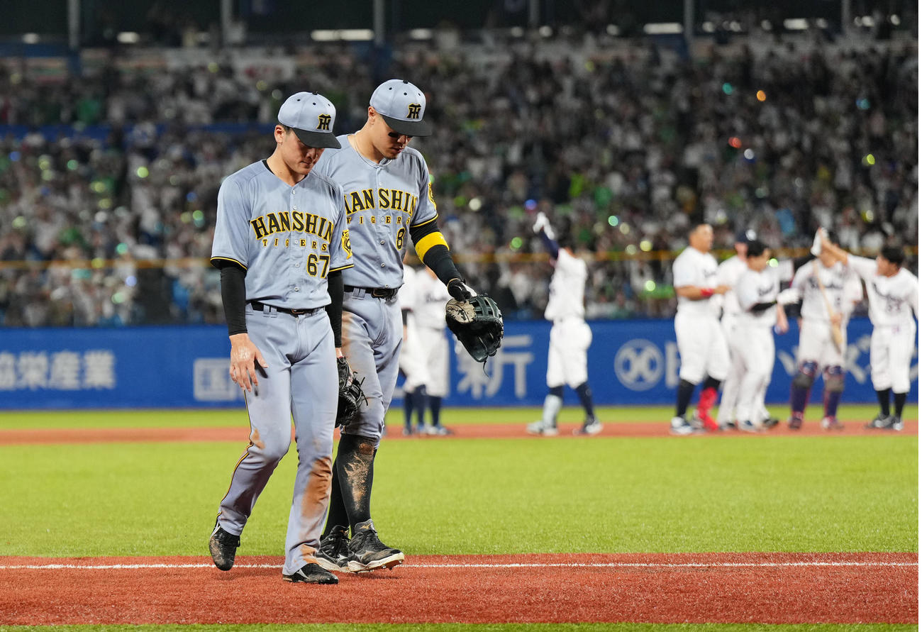 ヤクルト対阪神　9回裏ヤクルト2死二塁、内山の打球を失策しサヨナラ負けを喫し、佐藤（右）に声をかけられ引き揚げる高寺（撮影・菅敏）