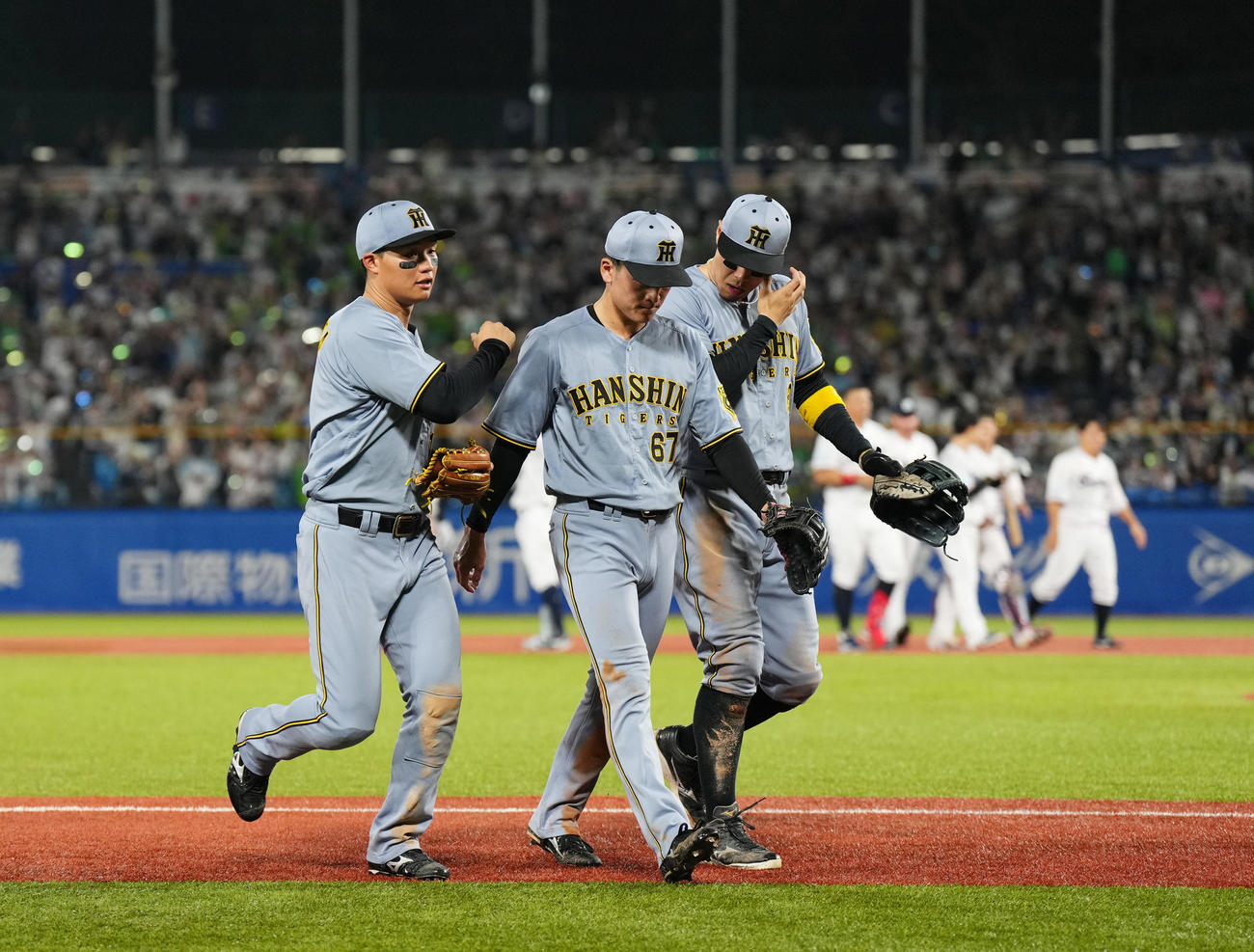 ヤクルト対阪神　9回裏ヤクルト2死二塁、内山の打球を失策しサヨナラ負けを喫し、森下（左）、佐藤輝（右）に声をかけられ引き揚げる高寺（撮影・菅敏）