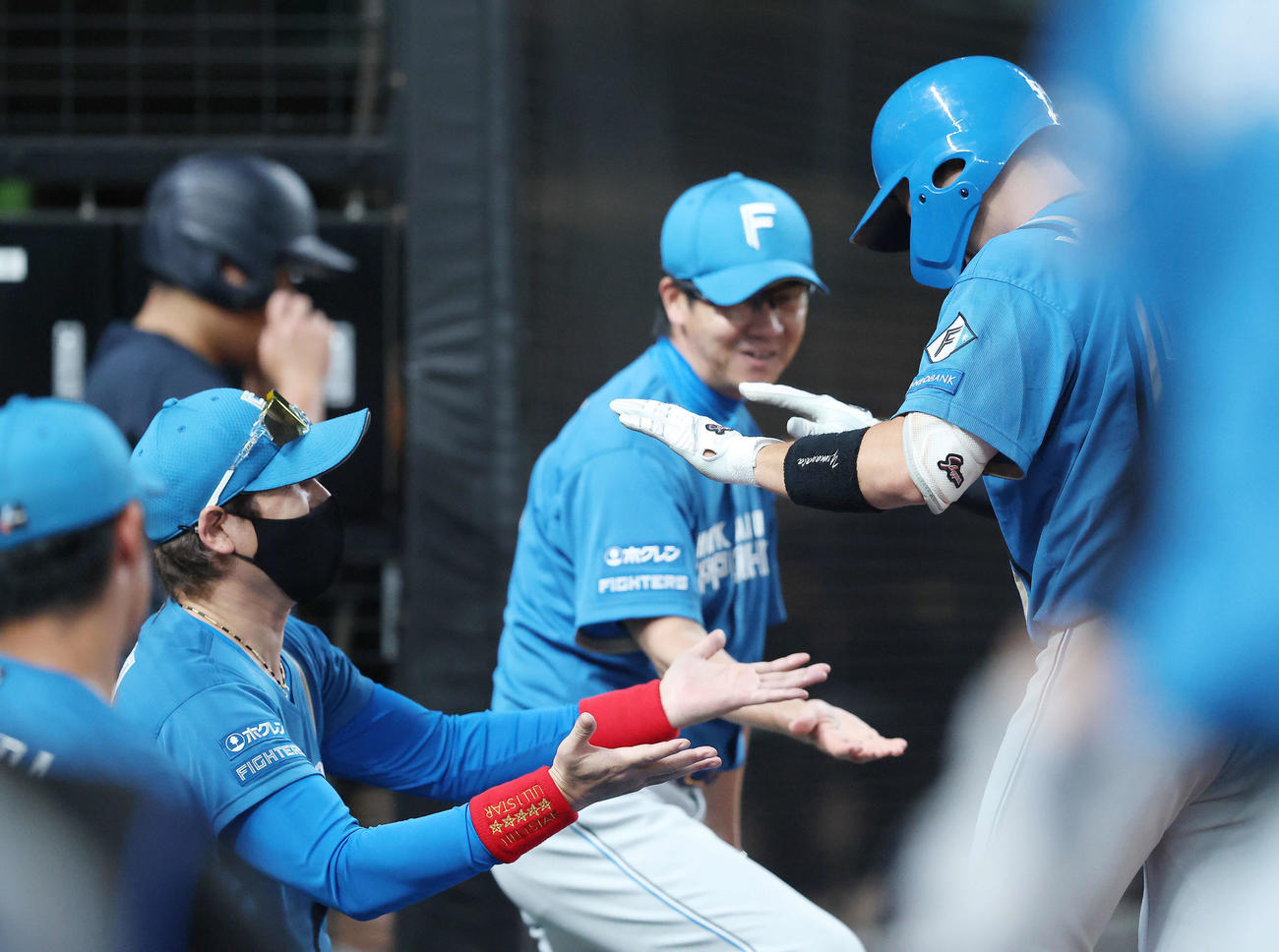 西武対日本ハム　8回表日本ハム1死二、三塁、中犠飛で追加点を挙げ、ベンチに戻る山県（右）を迎える新庄監督（撮影・河田真司）
