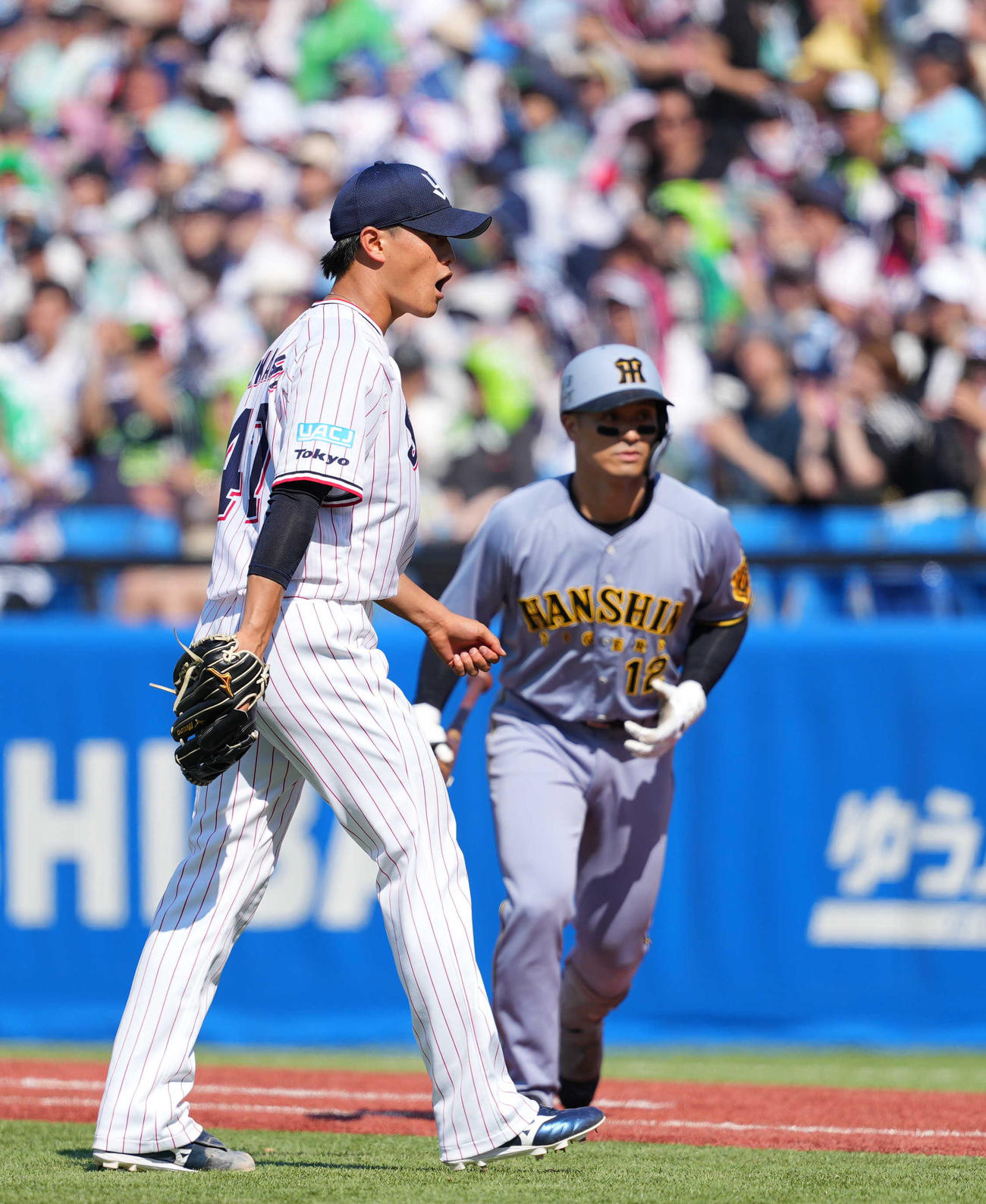 ヤクルト対阪神　4回表阪神2死一、三塁、坂本（後方）を一邪飛に打ち取り、ほえるヤクルト先発の高橋（撮影・狩俣裕三）