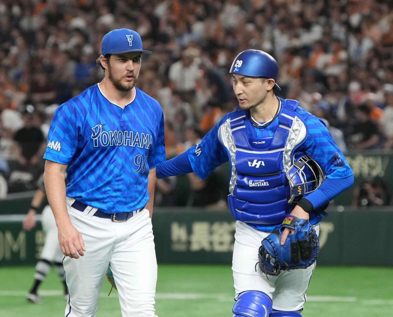 巨人対DeNA　2回の投球を終えベンチへ引き揚げるDeNA先発のバウアー。右は伊藤（撮影・小沢裕）