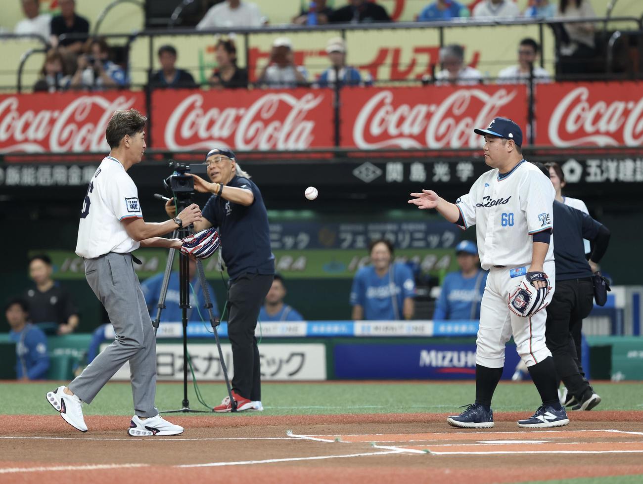 西武対日本ハム　開始前、セレモニアルピッチを終え、捕手を務めた西武中村剛（右）から記念球を受け取るG．G．佐藤氏（撮影・河田真司）