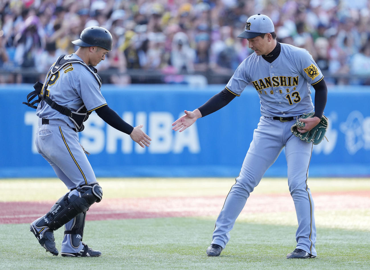 ヤクルト対阪神　ヤクルトに勝利し、坂本（左）とタッチを交わす阪神岩崎（撮影・鈴木みどり）