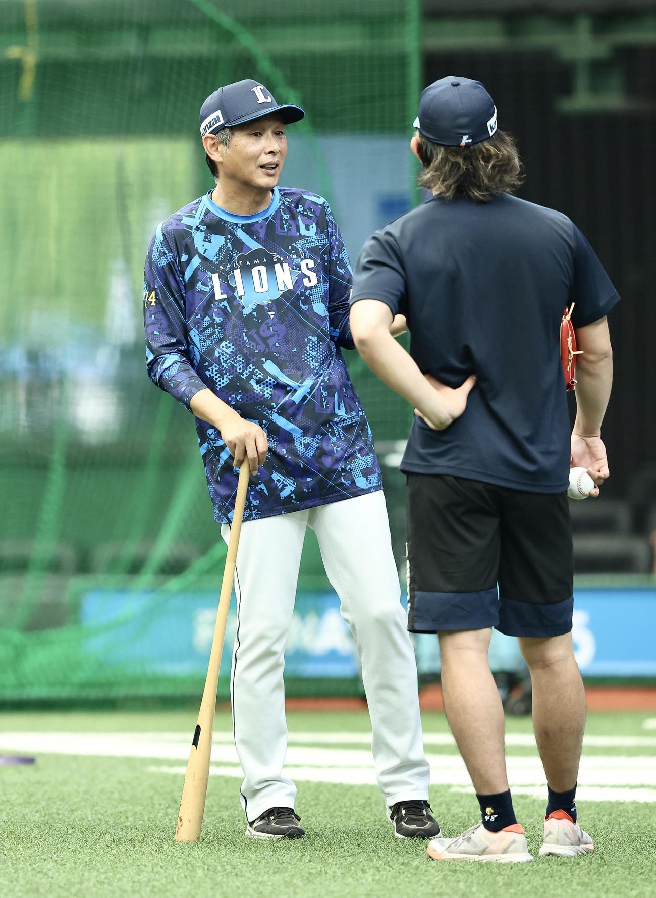 西武対日本ハム　試合前、今井（右）と言葉を交わす西武西口監督（撮影・河田真司）