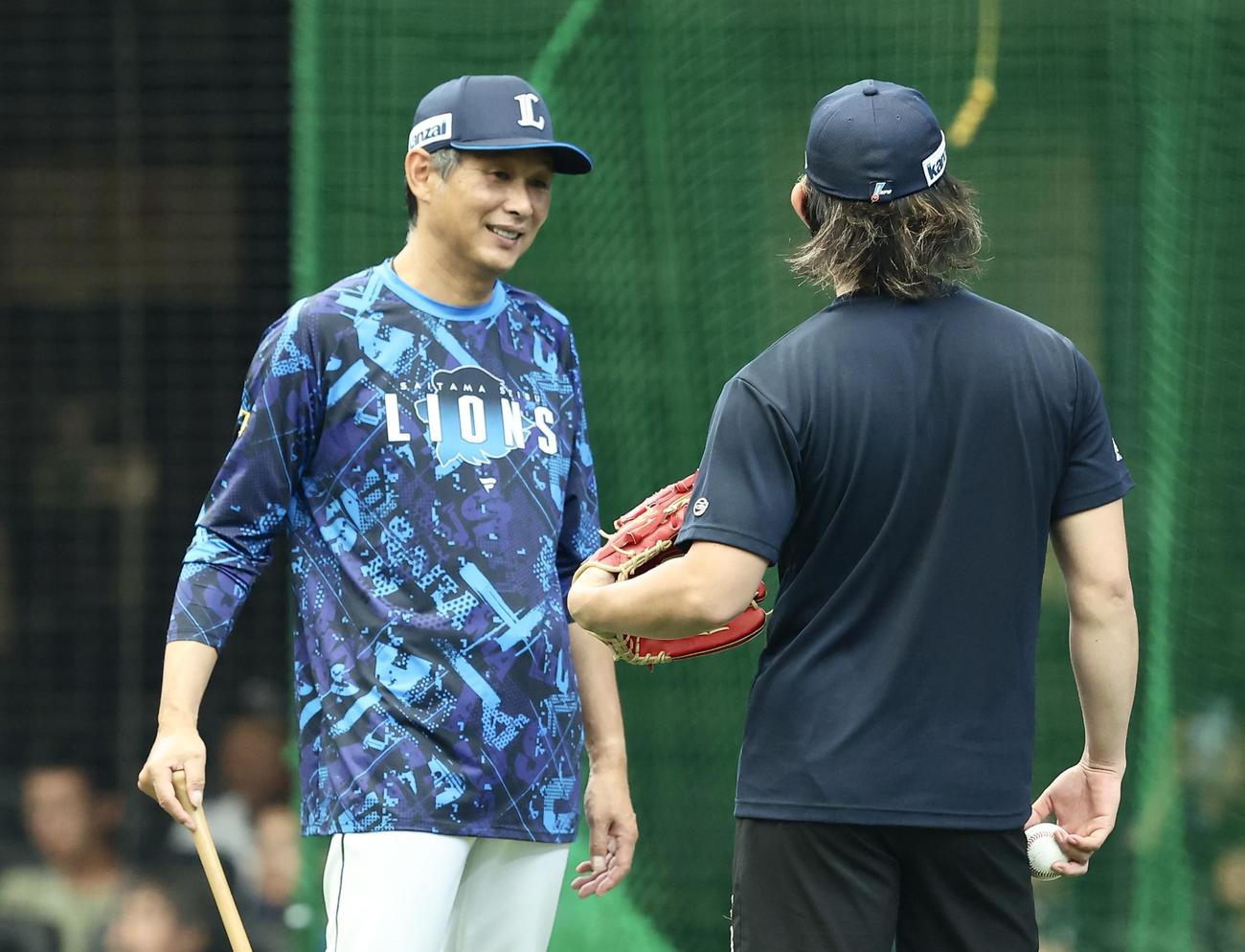西武対日本ハム　試合前、今井（右）と言葉を交わす西武西口監督（撮影・河田真司）