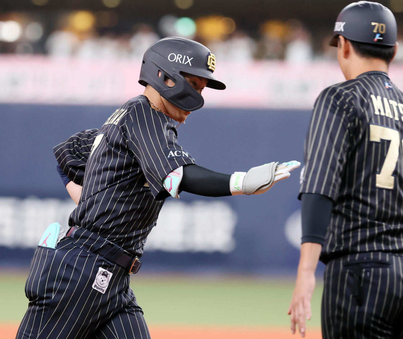 オリックス対楽天　1回裏オリックス無死、西川は中越えソロ本塁打を放ち松井コーチ（右）とタッチする（撮影・加藤哉）