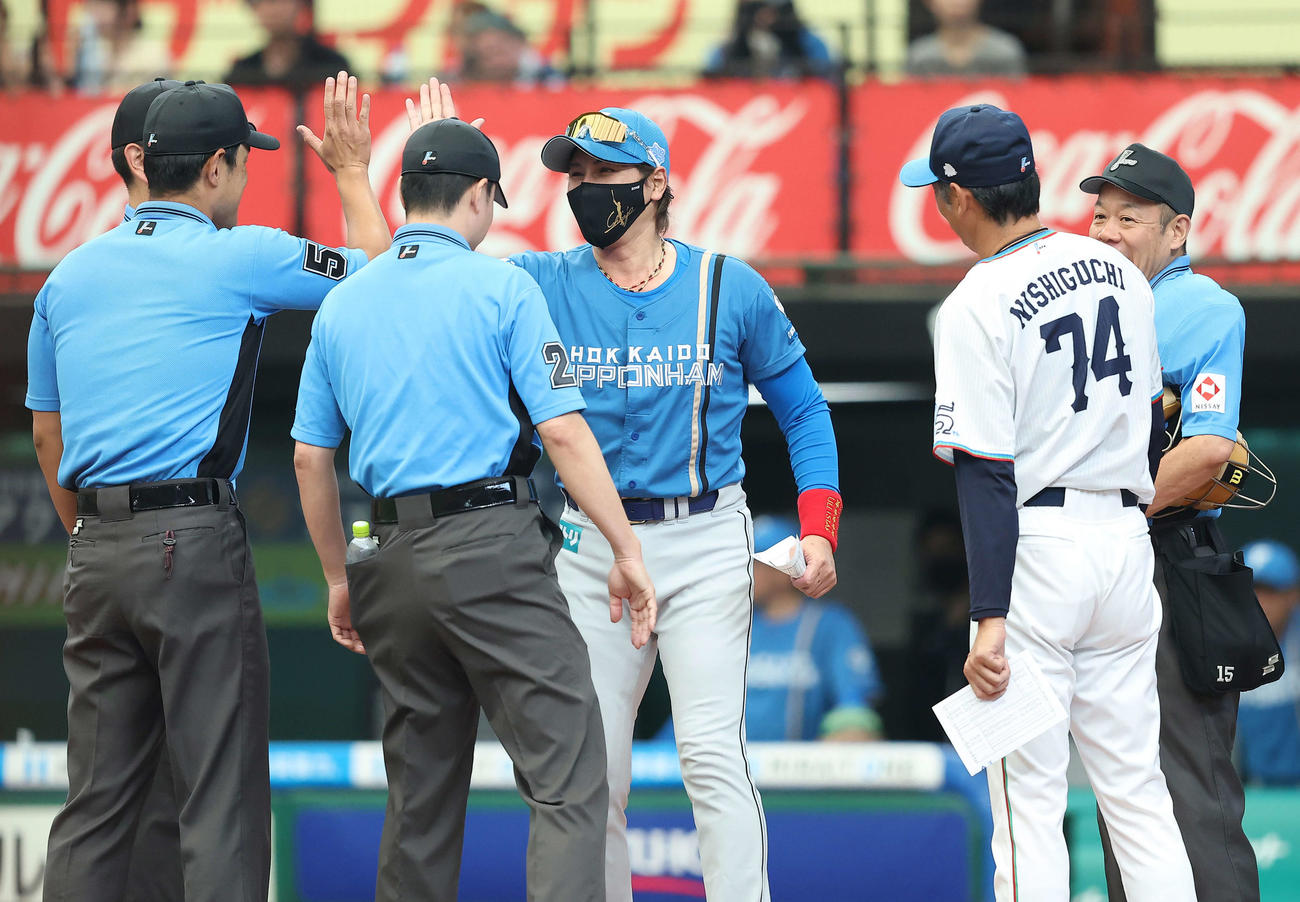 西武対日本ハム　開始前、西武西口監督（右から2人目）とメンバー表交換後、審判とタッチを交わす日本ハム新庄監督（中央）（撮影・河田真司）