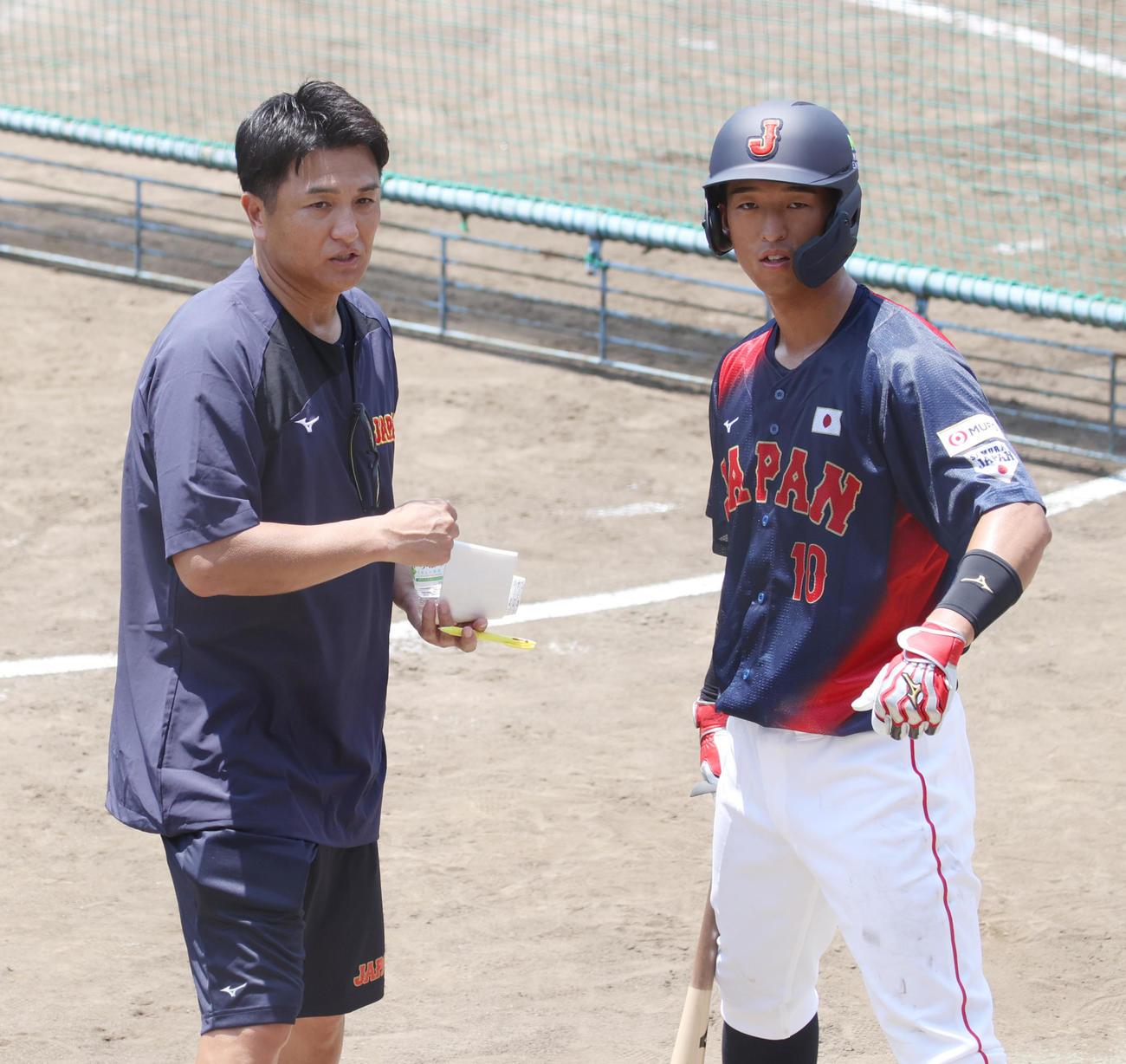 侍ジャパン大学代表直前合宿で桐蔭学園の後輩の法大・松下にアドバイスする元巨人監督の高橋由伸臨時コーチ（左）（撮影・柴田隆二）