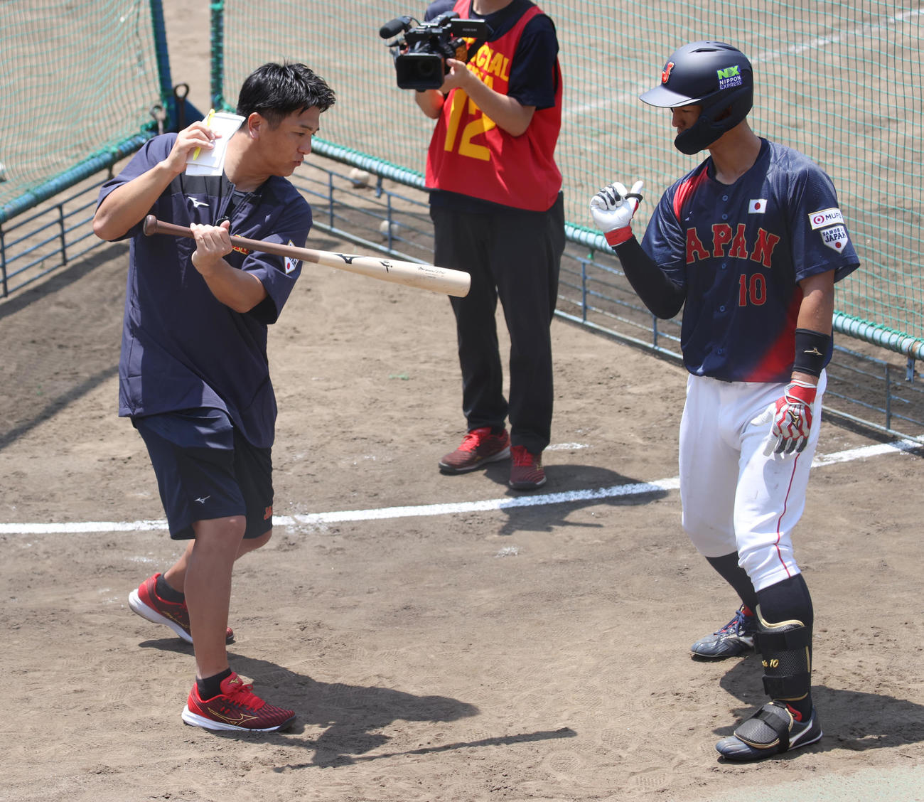 侍ジャパン大学代表直前合宿で桐蔭学園の後輩の法大・松下にアドバイスする元巨人監督の高橋由伸臨時コーチ（左）（撮影・柴田隆二）