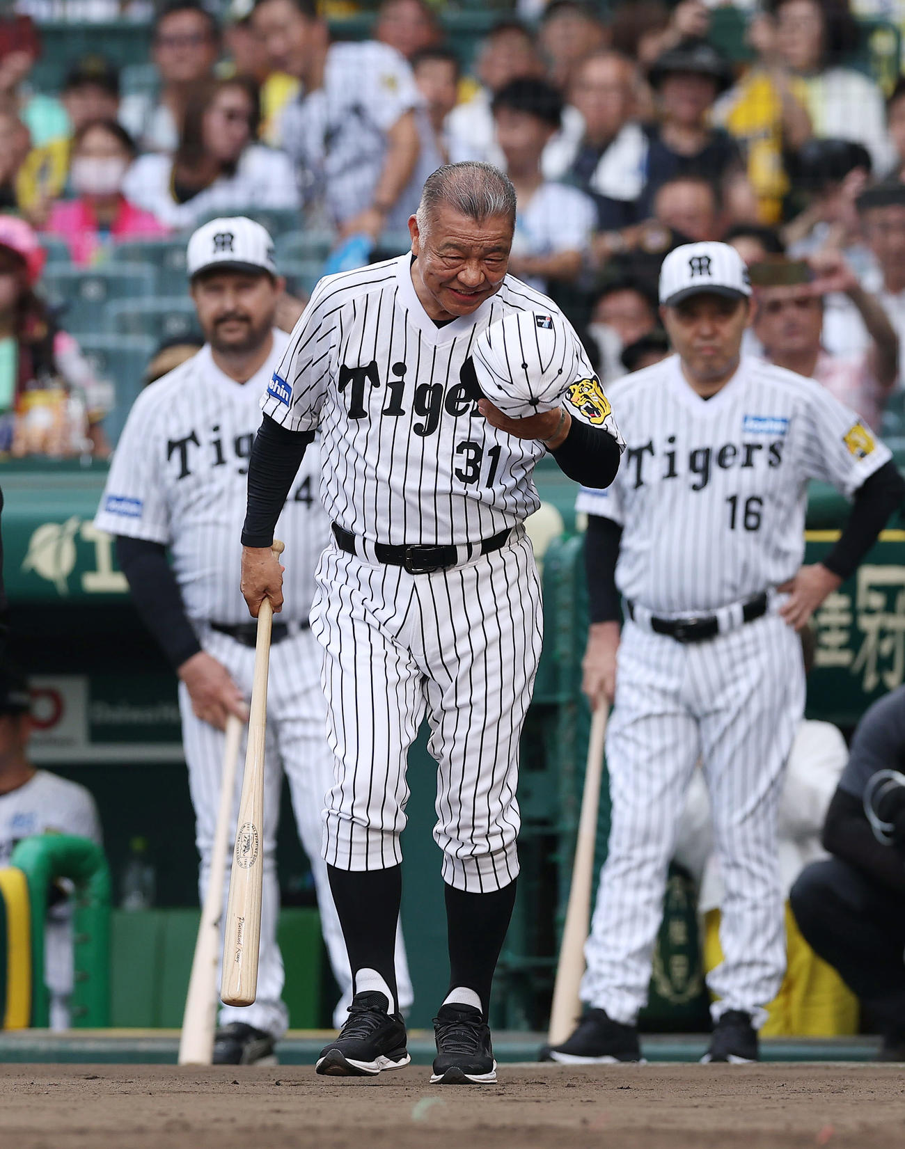 阪神対巨人　試合前、「バックスクリーン3連発」を再現する打席に向かう阪神掛布OB会長。右は岡田オーナー付顧問、左はバース氏（撮影・前田充）