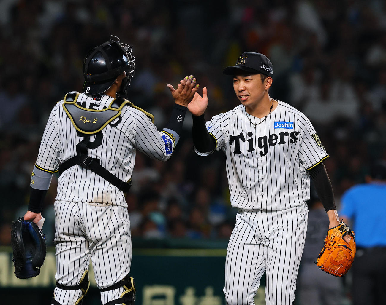 阪神対巨人　8回表巨人2死一、三塁、門脇を左飛に打ち取り、梅野（左）とタッチを交わす石井（撮影・藤尾明華）