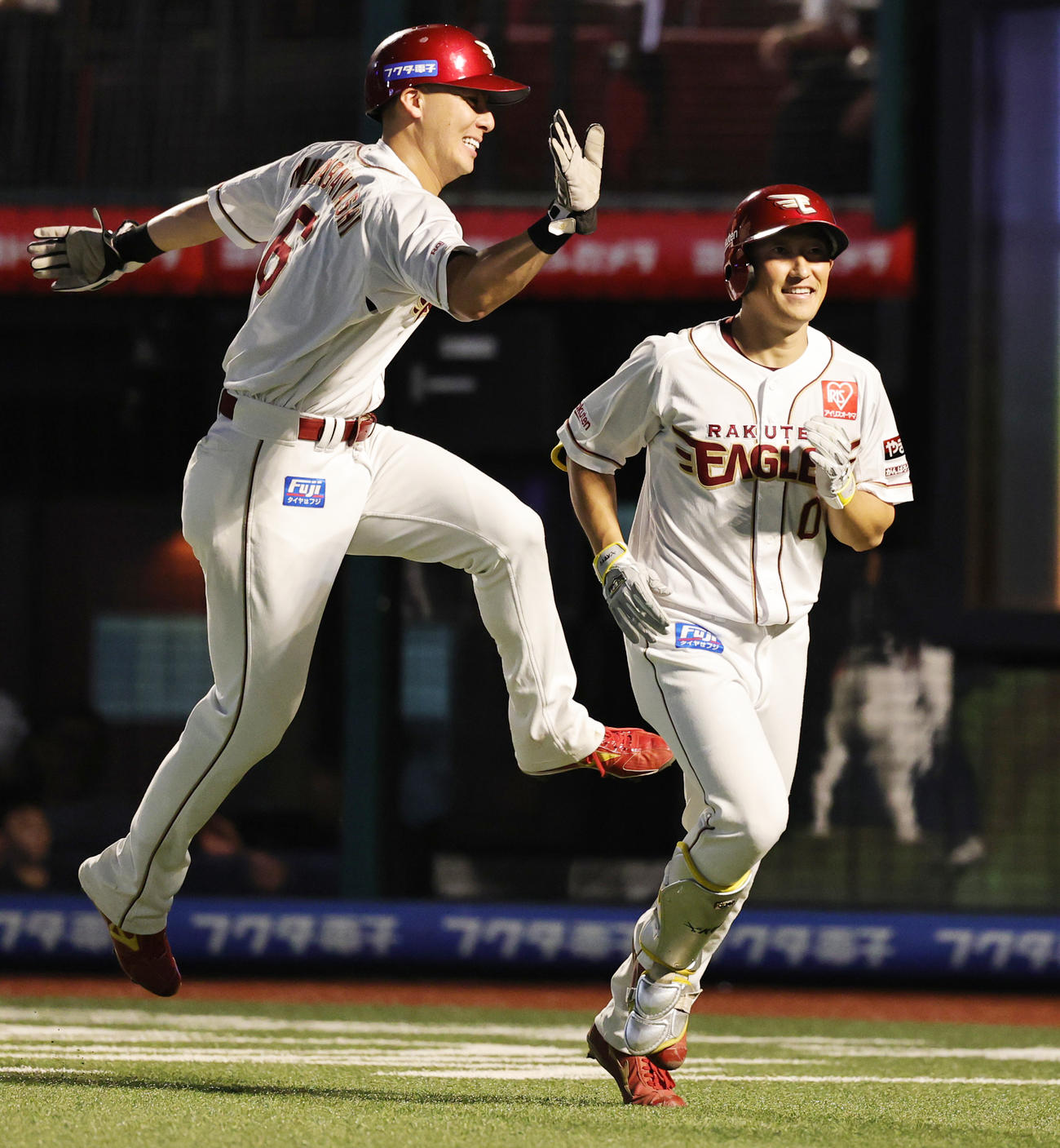 楽天対ロッテ　8回裏楽天無死一塁、右越え2点本塁打を放ち、村林（左）に祝福される小深田（撮影・野上伸悟）