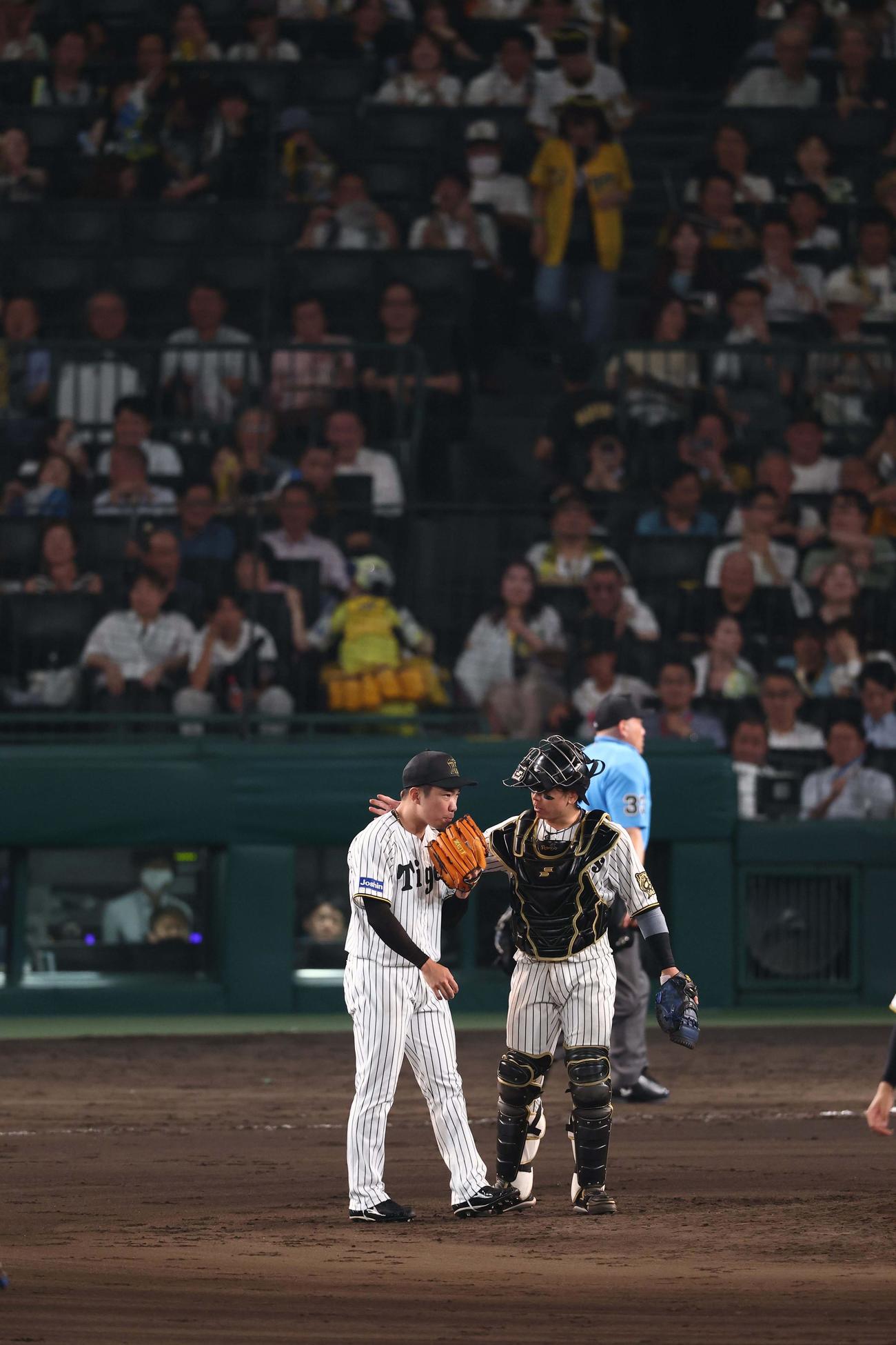 阪神対巨人　5番手の石井（左）は梅野に声を掛けられながらマウンドに上がる（撮影・上田博志）
