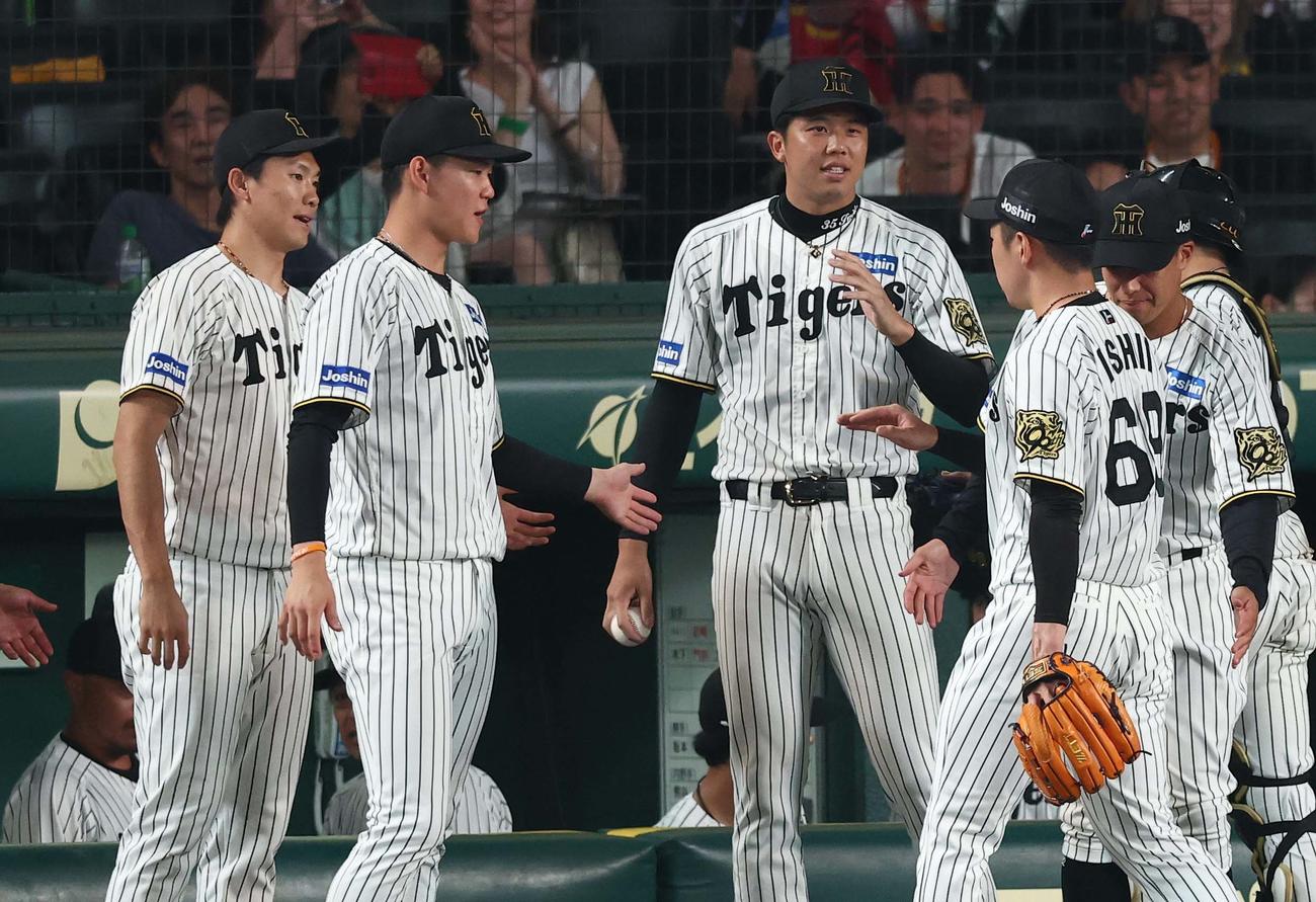 阪神対巨人　8回を無失点に抑えた石井（右から2人目）を出迎える左から湯浅、及川、才木（撮影・上田博志）