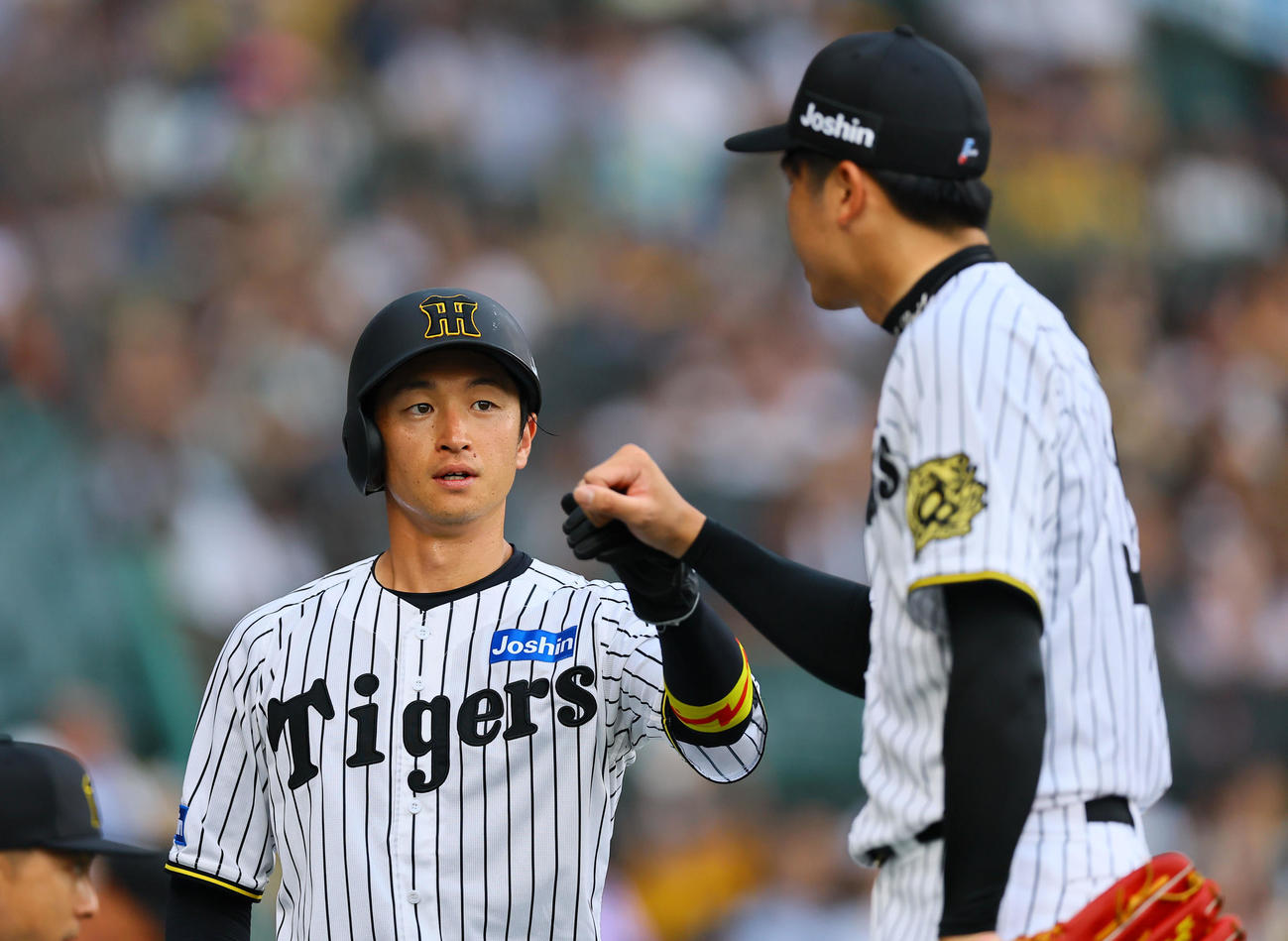 阪神対巨人　1回裏阪神2死二塁、佐藤輝の先制適時二塁打で生還し、才木とタッチを交わす近本（撮影・藤尾明華）