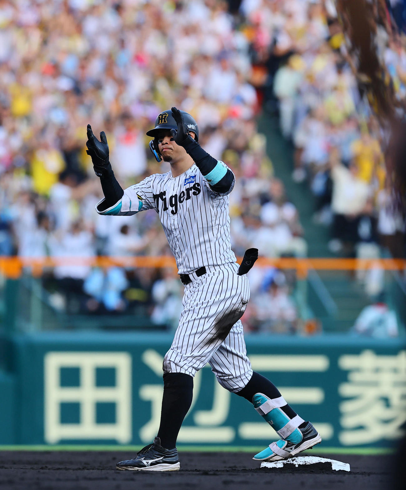 阪神対巨人　1回裏阪神2死二塁、佐藤輝は右越えに先制適時二塁打を放ち手をたたく（撮影・藤尾明華）