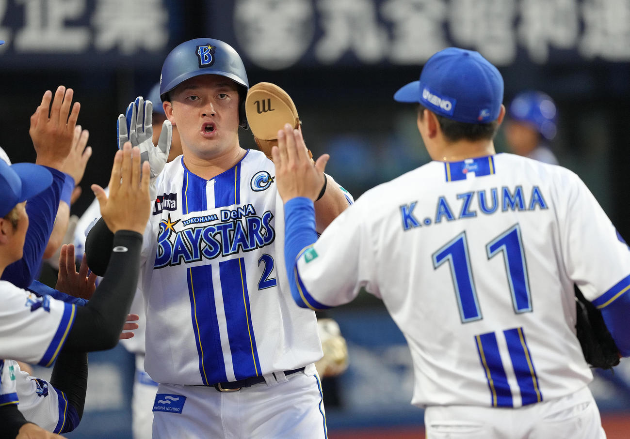 DeNA対中日　1回裏DeNA2死満塁、山本の適時内野安打で生還した牧（左）は東とタッチを交わす（撮影・足立雅史）