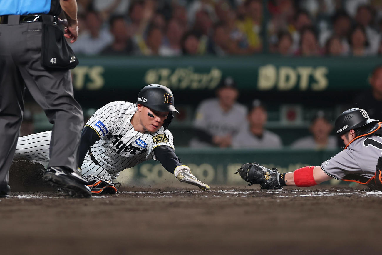 阪神対巨人　8回裏阪神2死一、二塁、大山の遊撃内野安打の間に生還する二走森下。捕手甲斐（撮影・前田充）