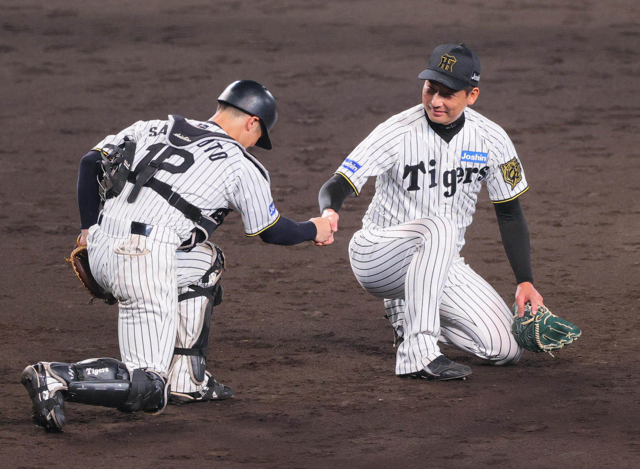 阪神対巨人　巨人に勝利し、試合を締めた岩崎（右）は捕手坂本と握手する（撮影・上山淳一）