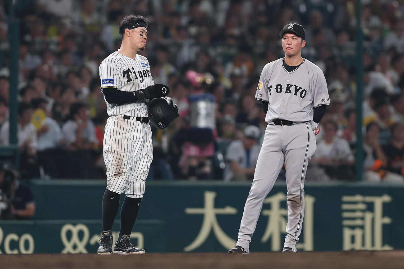 阪神対巨人　8回裏、リプレー検証の間に言葉を交わす阪神佐藤輝（左）と巨人坂本（撮影・前田充）