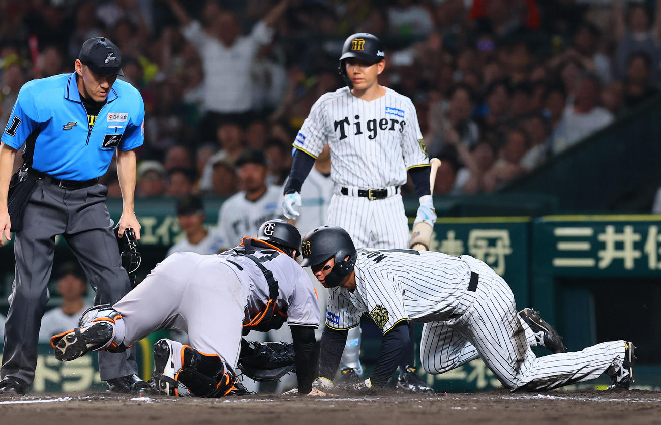 阪神対巨人　8回裏阪神2死一、二塁、大山の遊撃適時内野安打で生還する森下。捕手甲斐。判定はアウトもリクエストでセーフとなる（撮影・藤尾明華）