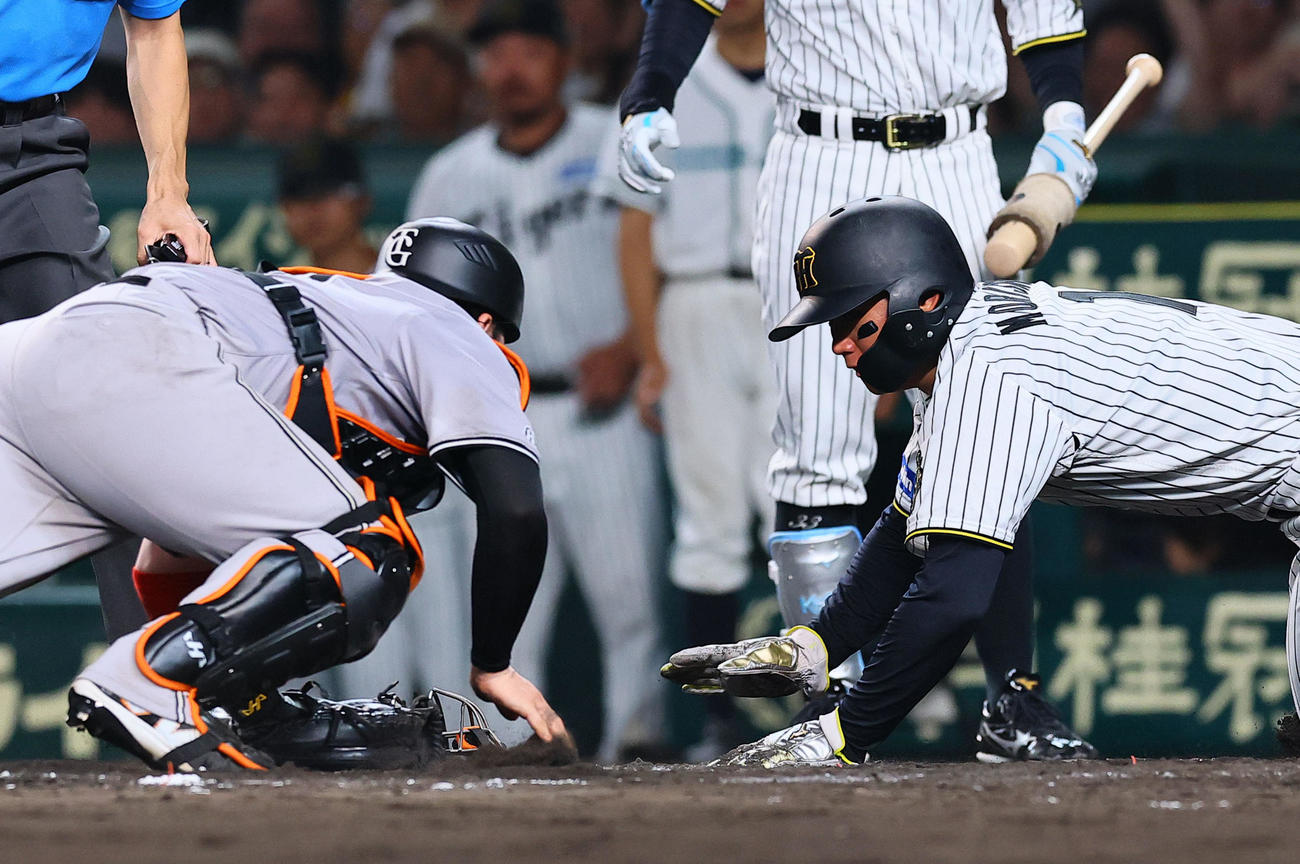 阪神対巨人　8回裏阪神2死一、二塁、大山の遊撃適時内野安打で生還する森下。捕手甲斐。判定はアウトもリクエストでセーフとなる（撮影・藤尾明華）