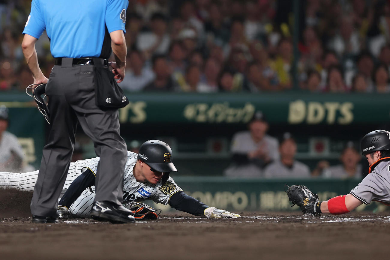 阪神対巨人　8回裏阪神2死一、二塁、大山の遊撃内野安打の間に生還する二走森下。捕手甲斐（撮影・前田充）