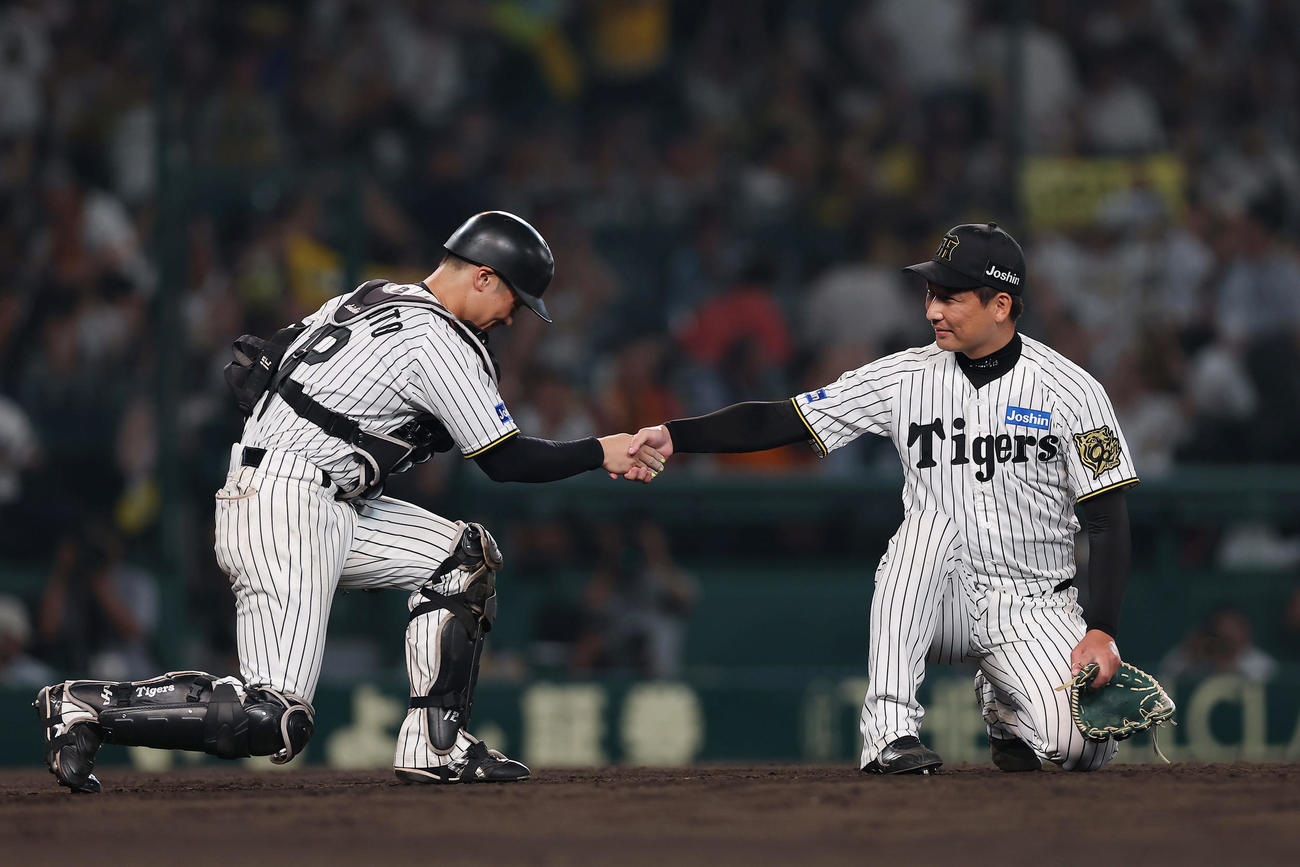 阪神対巨人　巨人に勝利し、握手を交わす阪神坂本（左）と岩崎（撮影・前田充）