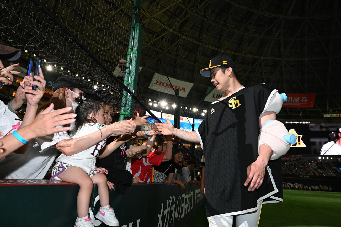 ソフトバンク対日本ハム　ファンとタッチを交わす松本晴（右）（撮影・林敢治）
