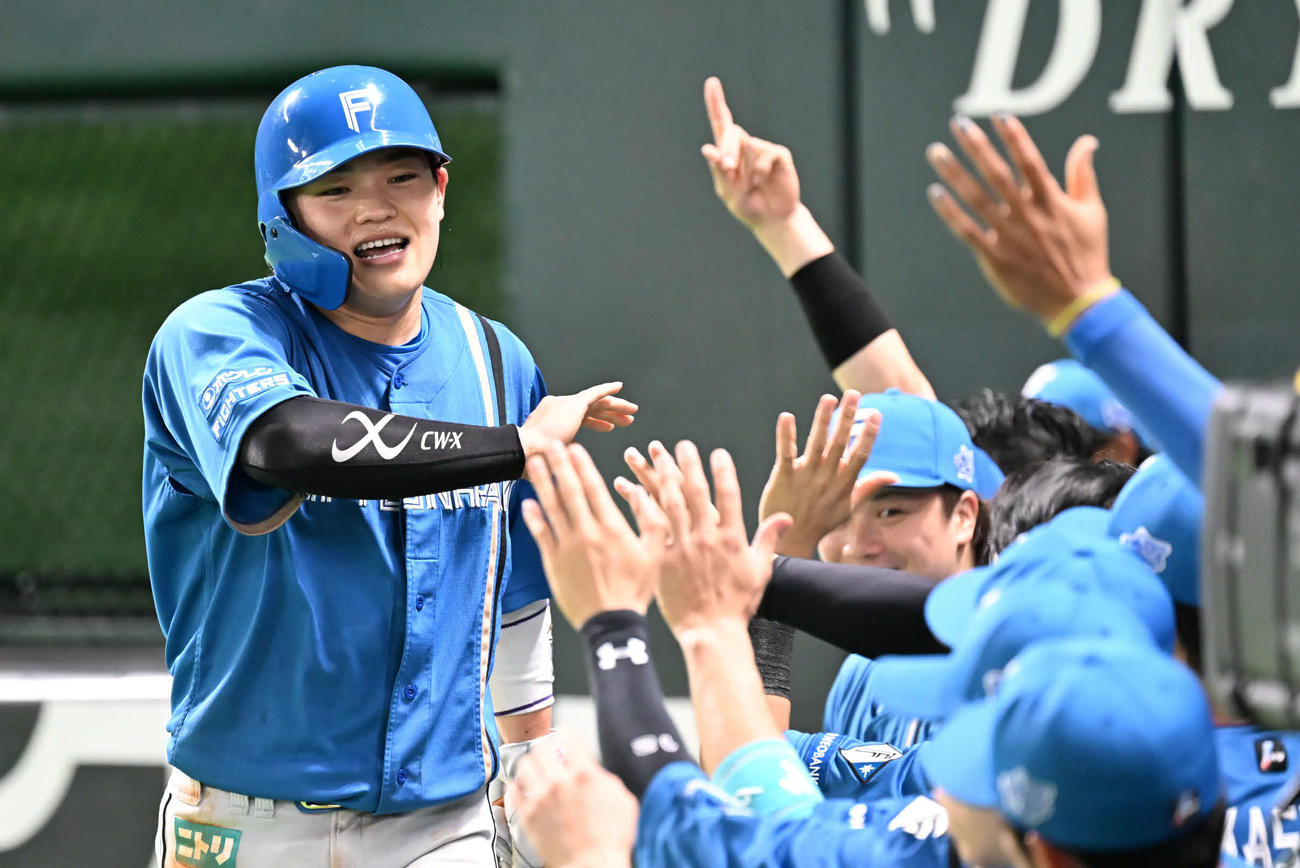 ソフトバンク対日本ハム　3回表日本ハム2死一塁、生還した田宮（左）はナインとタッチを交わす（撮影・林敢治）