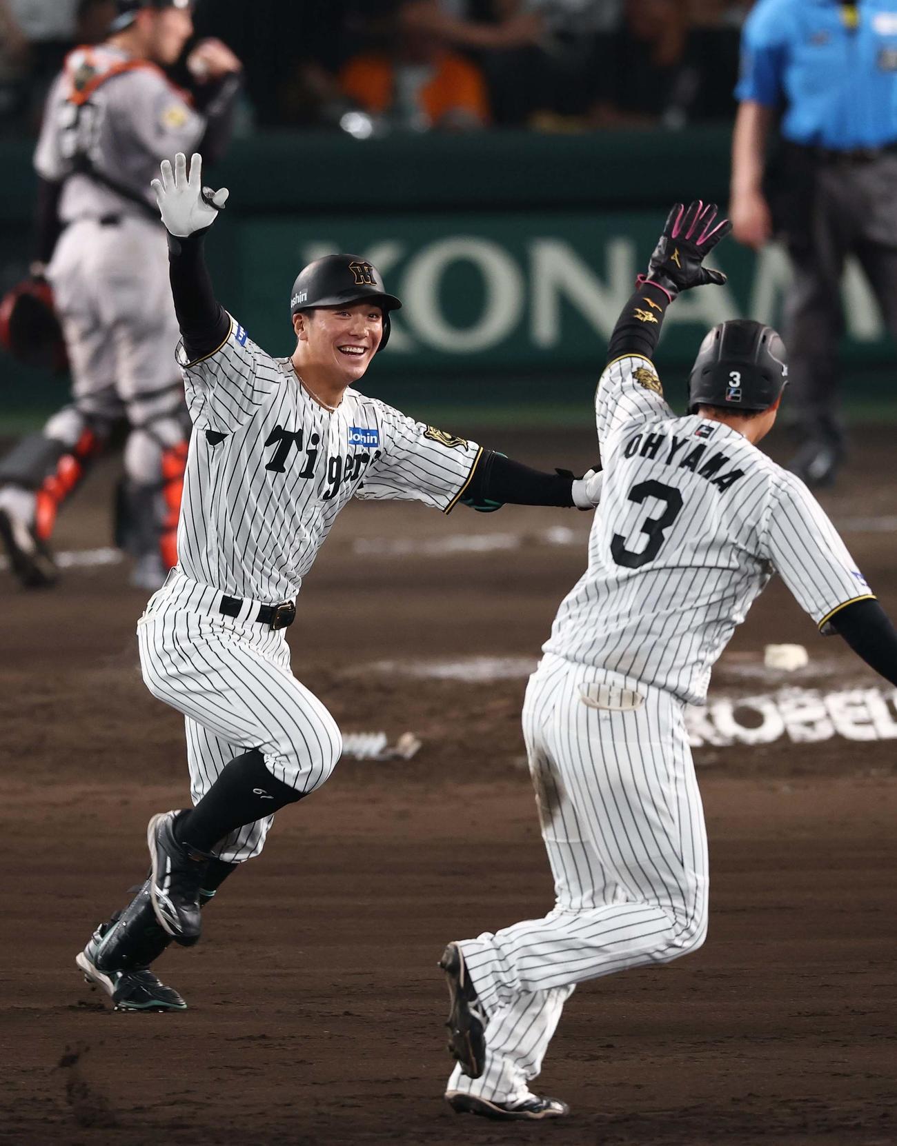 阪神対巨人　9回裏阪神無死満塁、サヨナラ犠飛を放った豊田（左）は笑顔を見せる（撮影・上田博志）