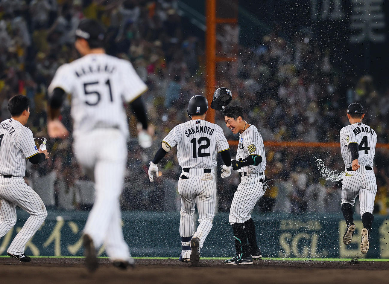 阪神対巨人　9回裏阪神無死満塁、サヨナラの中犠飛を放ち祝福を受ける豊田（右から2人目）（撮影・藤尾明華）