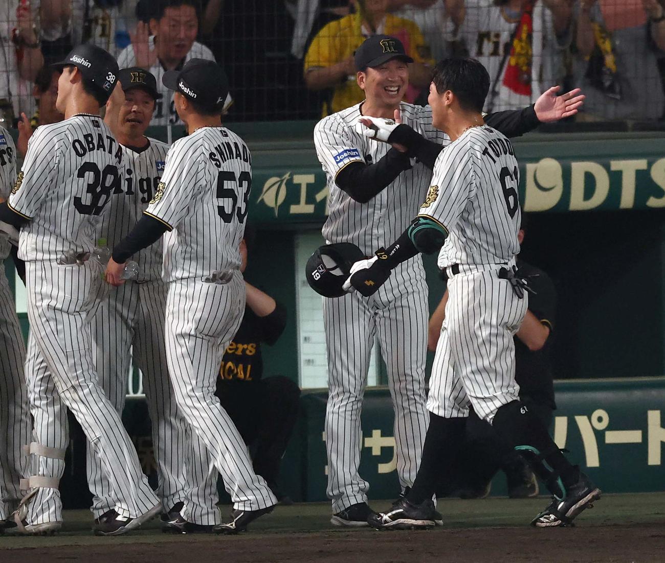 阪神対巨人　9回裏阪神無死満塁、サヨナラ犠飛を放った豊田（右）を笑顔で出迎える藤川監督（撮影・上田博志）