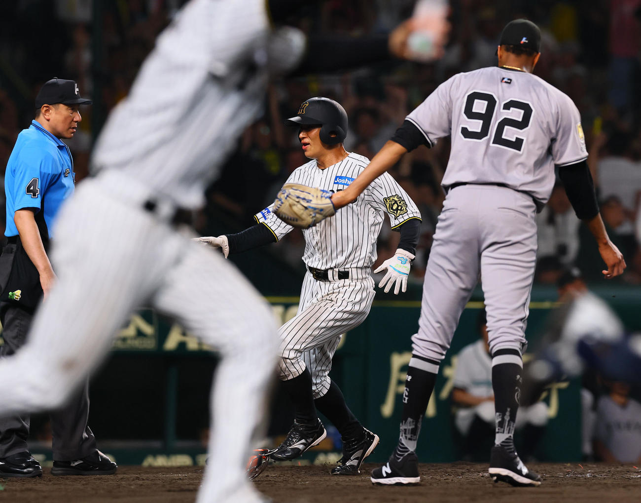 阪神対巨人　9回裏阪神無死満塁、豊田寛の中犠飛で生還する植田。右はマルティネス（撮影・藤尾明華）