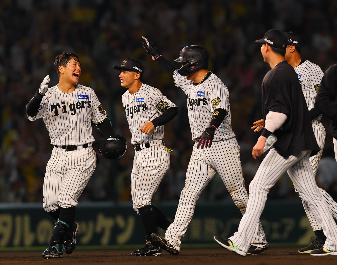 阪神対巨人　9回裏阪神無死満塁、サヨナラの中犠飛を放ち大山ら（中央）とタッチを交わす豊田（左端）（撮影・藤尾明華）