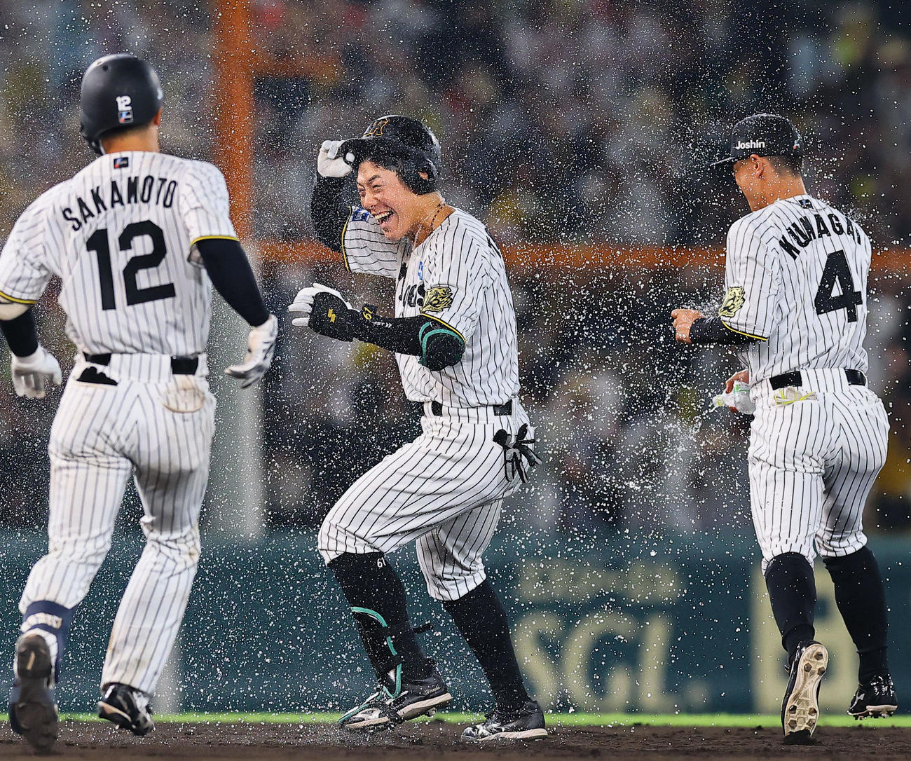 阪神対巨人　9回裏阪神無死満塁、サヨナラの中犠飛を放ち祝福を受ける豊田（中央）（撮影・藤尾明華）