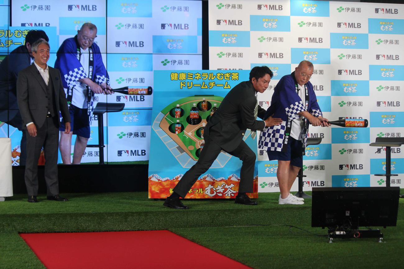 イベントで笑福亭鶴瓶に打撃指導する川崎さん。左は五十嵐さん