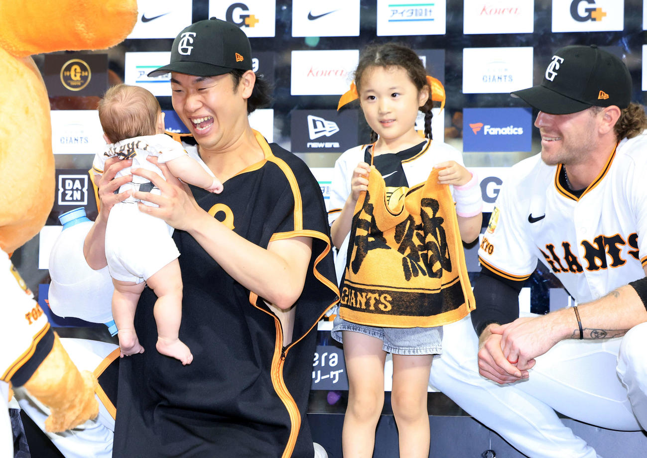 巨人対広島　8勝目の巨人山崎（左）は、ヒーローインタビュー後、ファンの赤ちゃんを抱き上げ笑顔が弾ける。右はキャベッジ（撮影・浅見桂子）