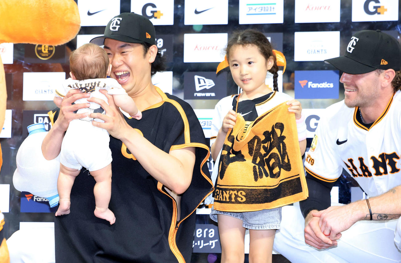 巨人対広島　8勝目の巨人山崎（左）は、ヒーローインタビュー後、ファンの赤ちゃんを抱き上げ笑顔が弾ける。右はキャベッジ（撮影・浅見桂子）