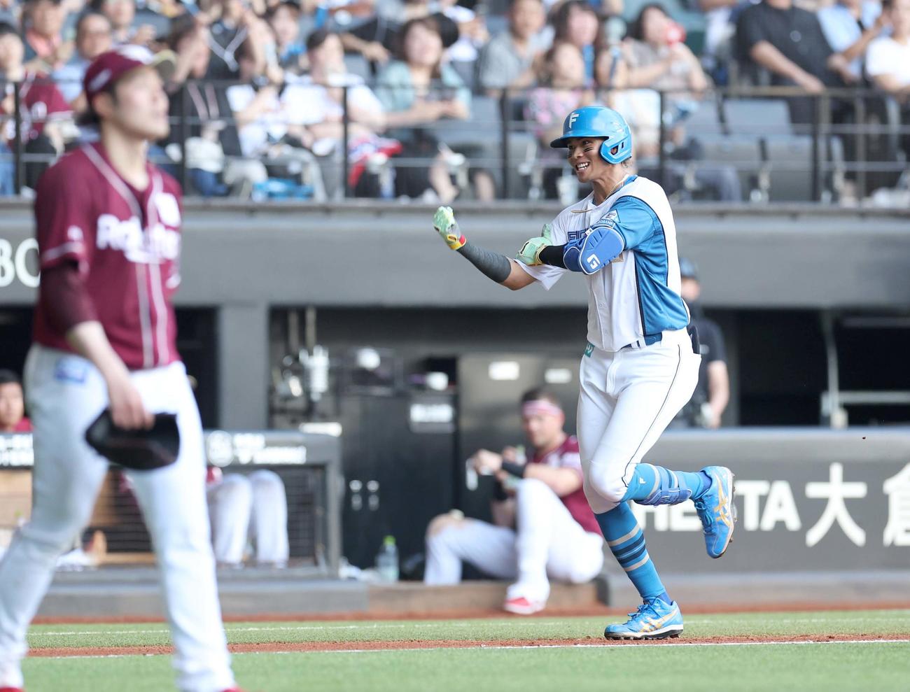 日本ハム対楽天　4回裏日本ハム無死二塁、右越え2点本塁打を放ちガッツポーズの水谷。左は滝中（撮影・黒川智章）