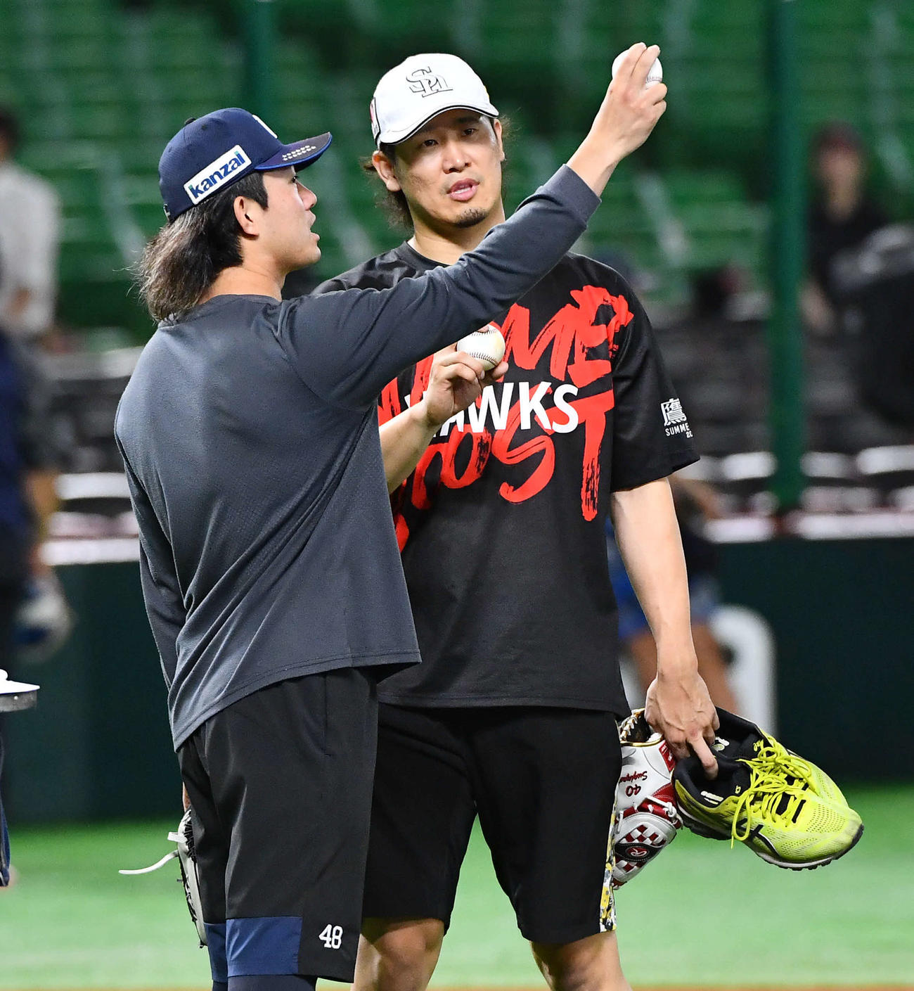 ソフトバンク対西武　試合前、西武今井（左）からスライダーを教わるソフトバンク杉山（撮影・岩下翔太）