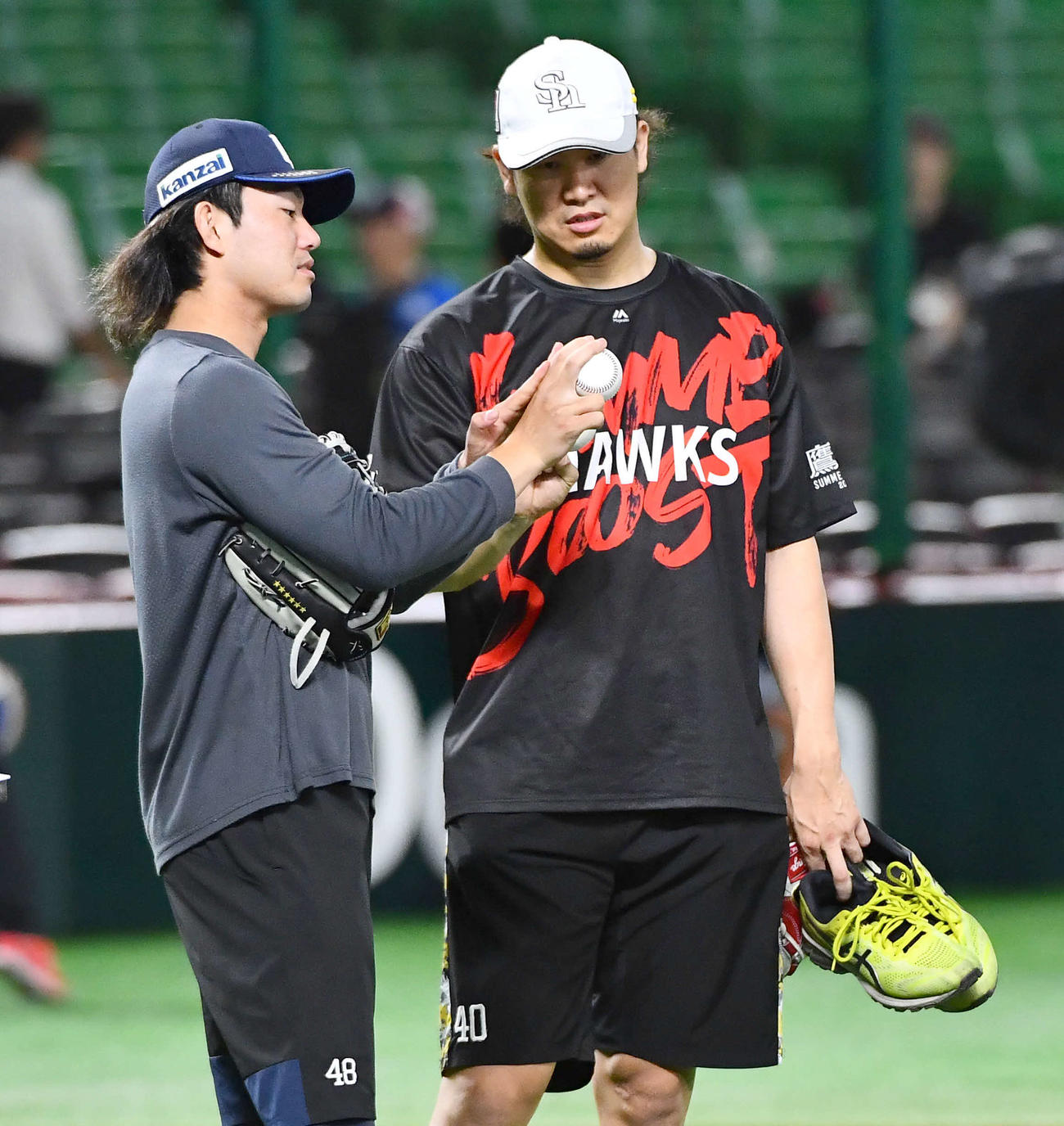 ソフトバンク対西武　試合前、西武今井（左）からスライダーを教わるソフトバンク杉山（撮影・岩下翔太）