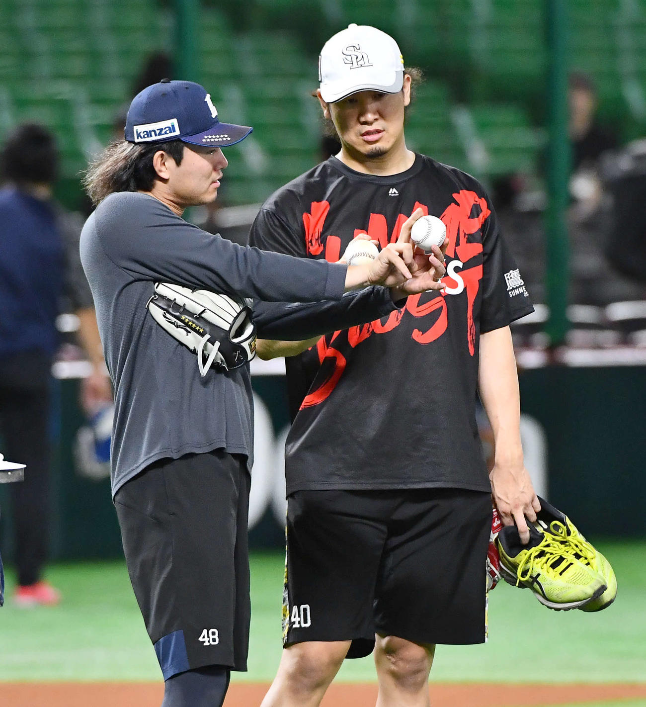ソフトバンク対西武　試合前、西武今井（左）からスライダーを教わるソフトバンク杉山（撮影・岩下翔太）