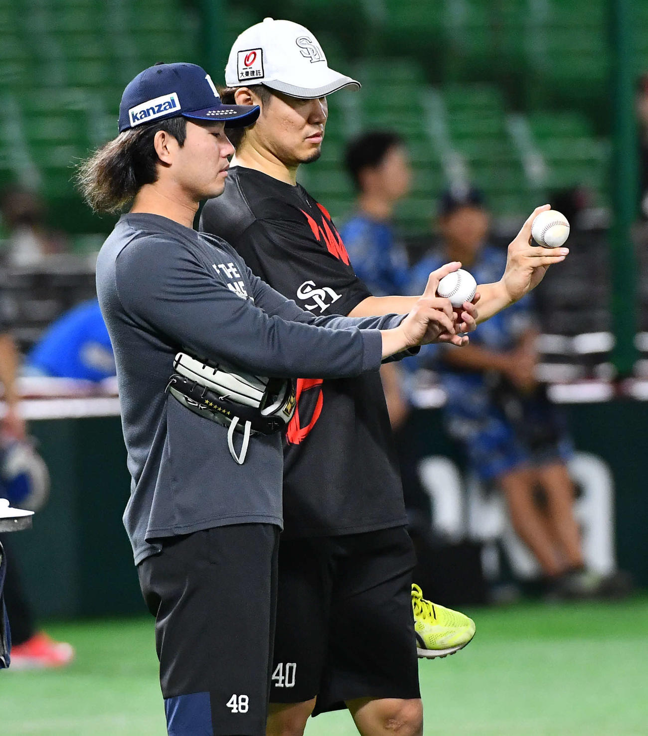 ソフトバンク対西武　試合前、西武今井（左）からスライダーを教わるソフトバンク杉山（撮影・岩下翔太）
