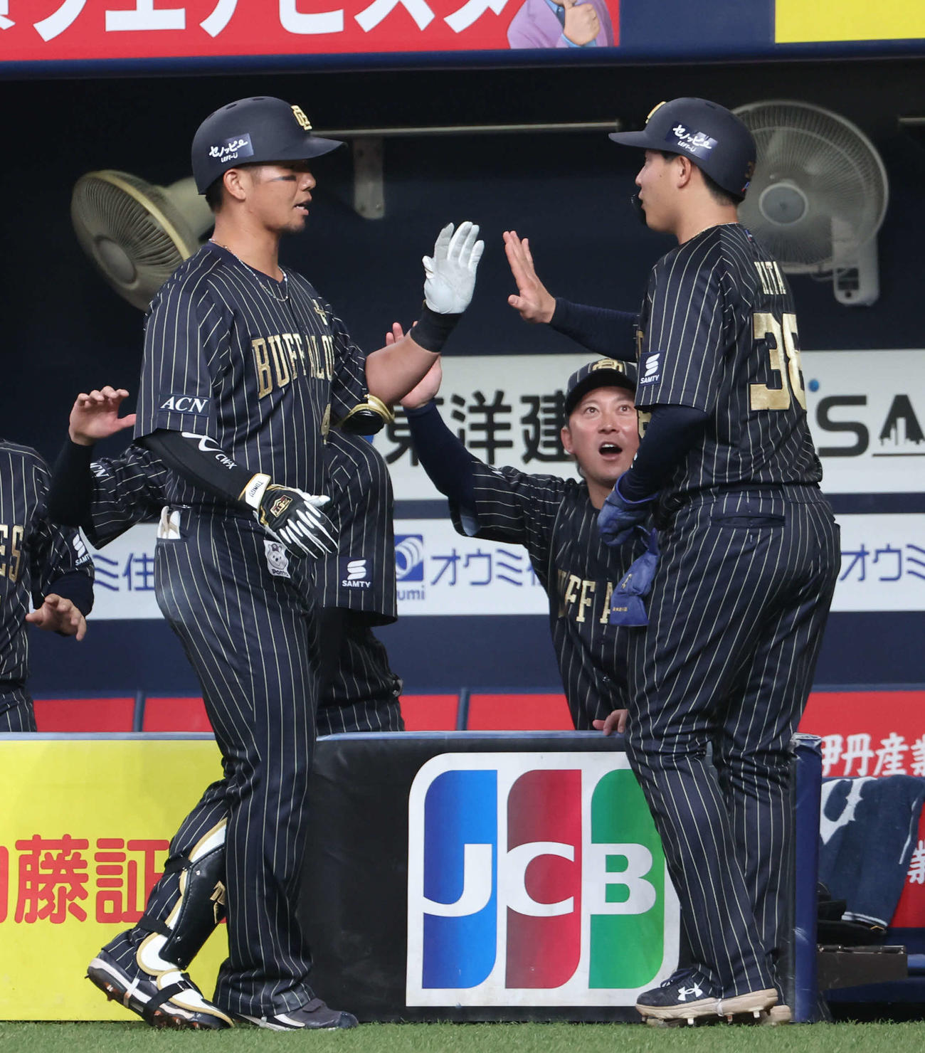 オリックス対ロッテ　3回裏オリックス1死二、三塁、犠飛を放った頓宮（左）と生還した来田はベンチ前でハイタッチ（撮影・西尾就之）