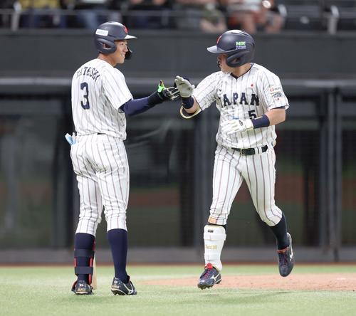 日米大学野球選手権　日本対米国　5回裏、本塁打を放つった小田（右）は生還し立石とタッチする（撮影・黒川智章）