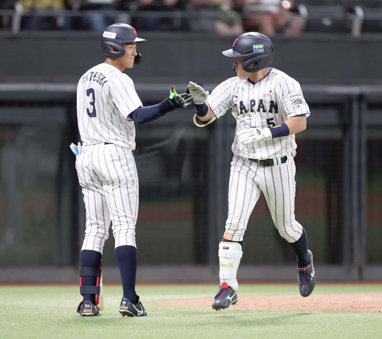 日米大学野球選手権　日本対米国　5回裏、本塁打を放つった小田（右）は生還し立石とタッチする（撮影・黒川智章）